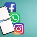 Meta logo on phone next to Facebook, Whatsapp and Instagram icons